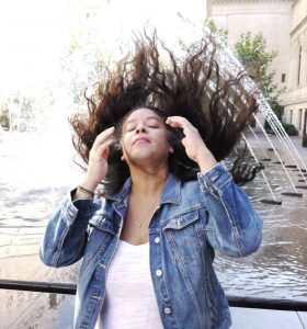 author flipping hair water shooting from fountain over hair